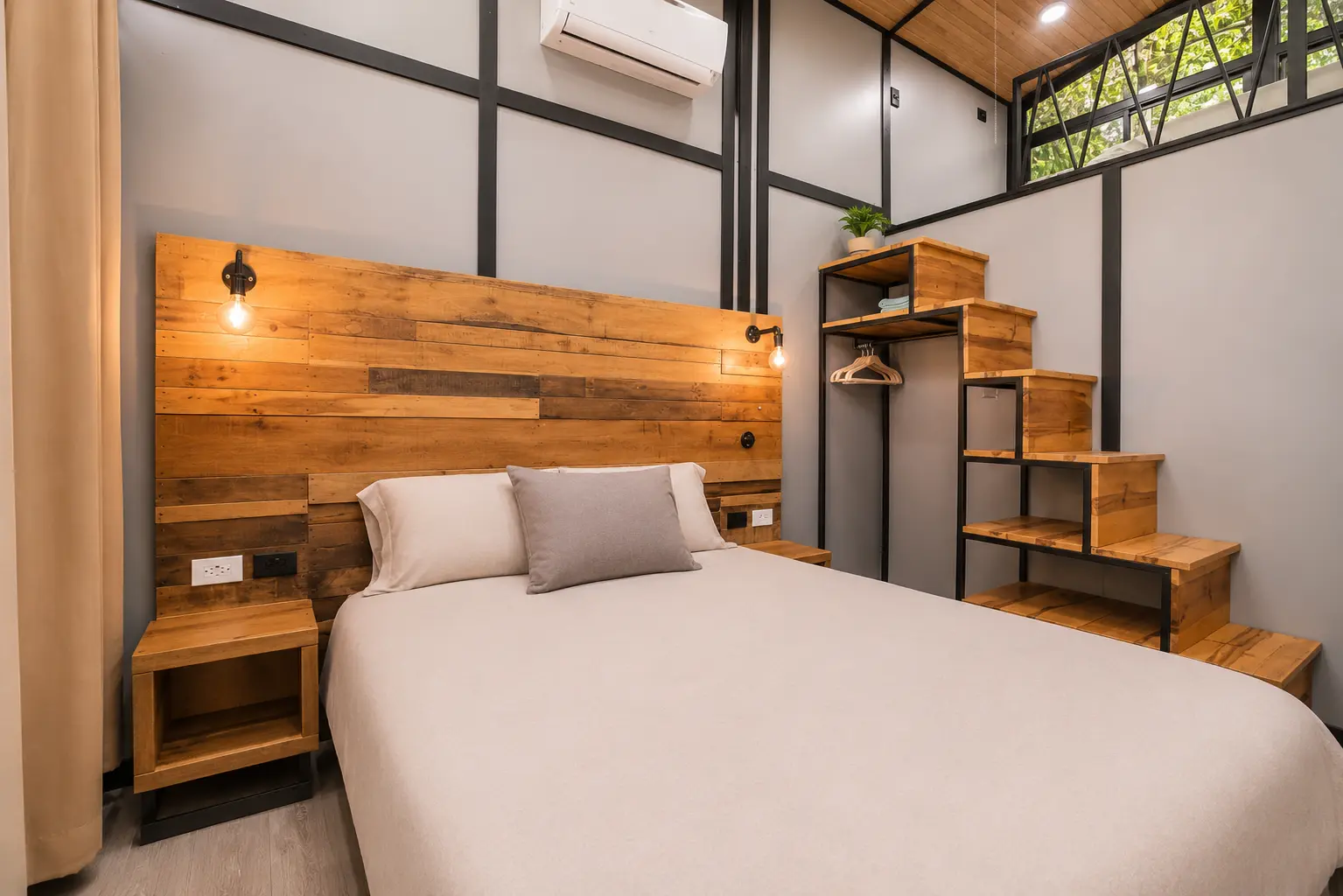 Air-conditioned bedroom with loft stairs in The Palm Jungalow