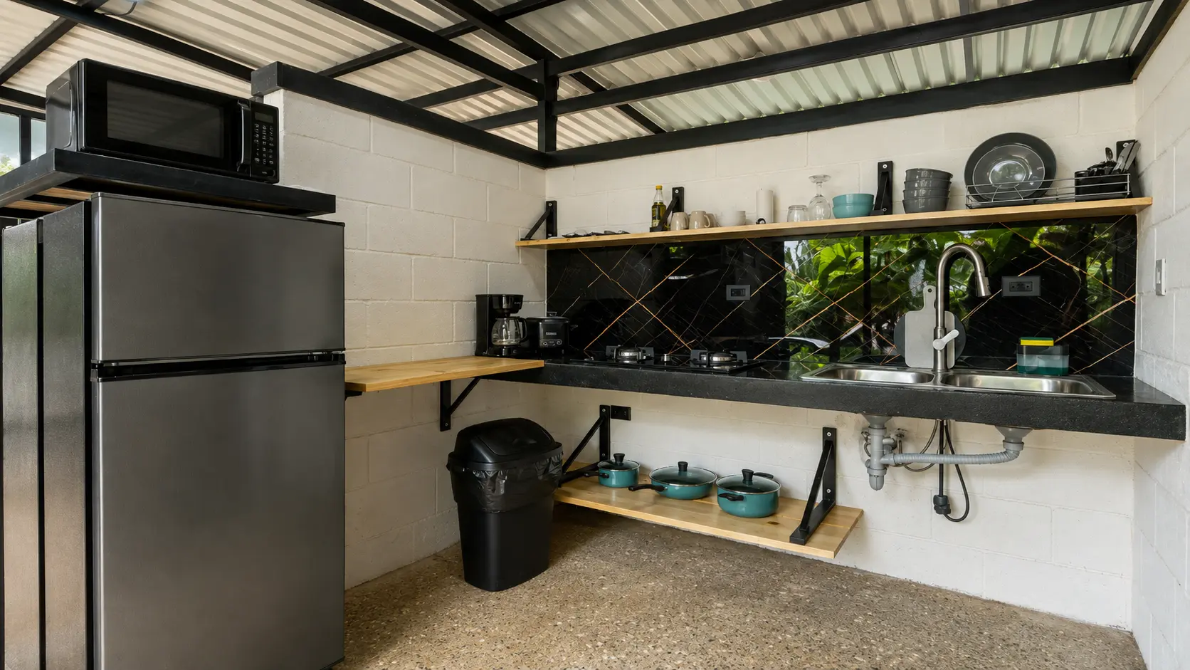 Pebble Jungalow outdoor kitchen with stainless cookware and jungle view